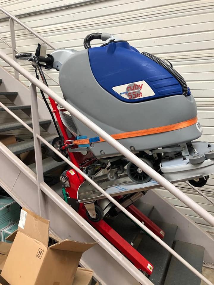 Tracked stair climber transporting industrial floor scrubber