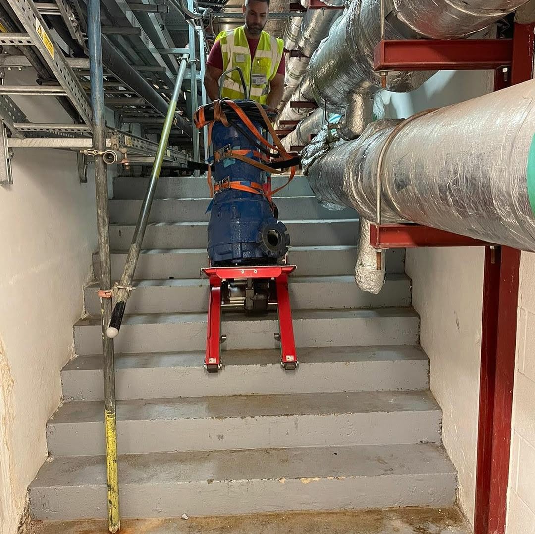 Carretilla sube escaleras para transporte de generador en obra