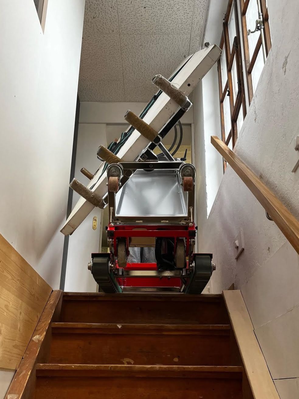 Carretilla sube escaleras para entrega de ventanas de PVC en apartamento