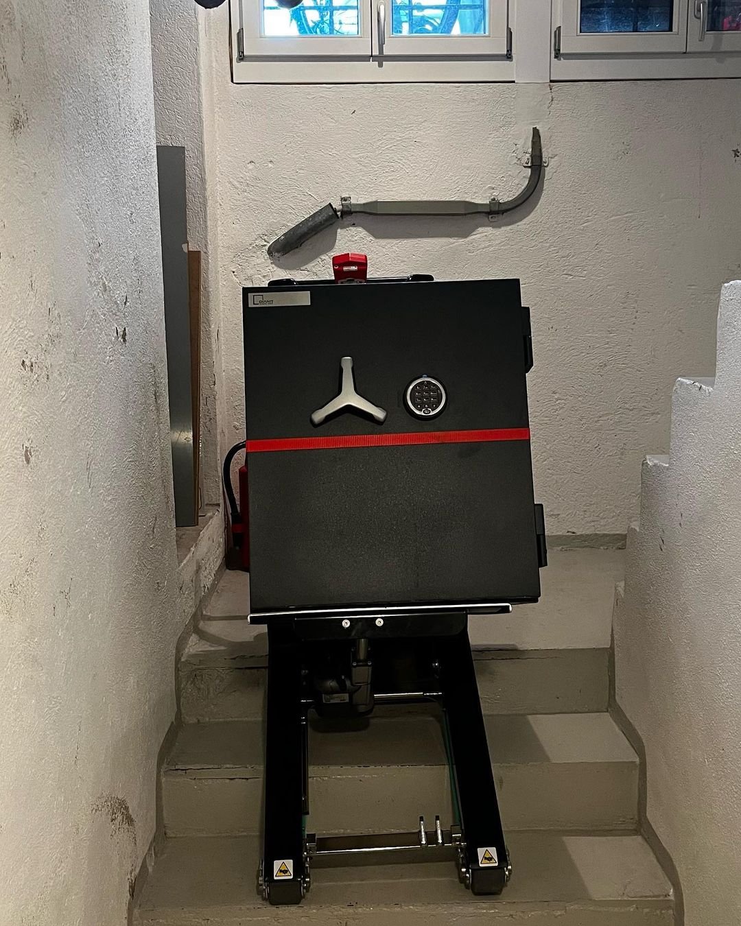 Transport de coffre-fort à armes dans les escaliers avec monte-escalier