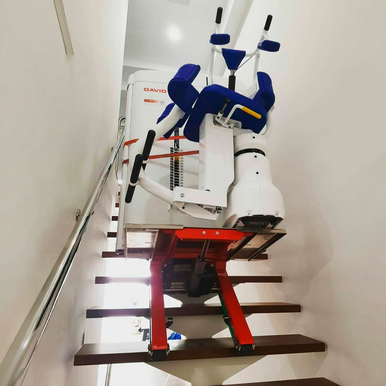 Trasporto di un macchinario medicale su una scala ripida in legno con il saliscale elettrico cingolato Domino di Zonzini
